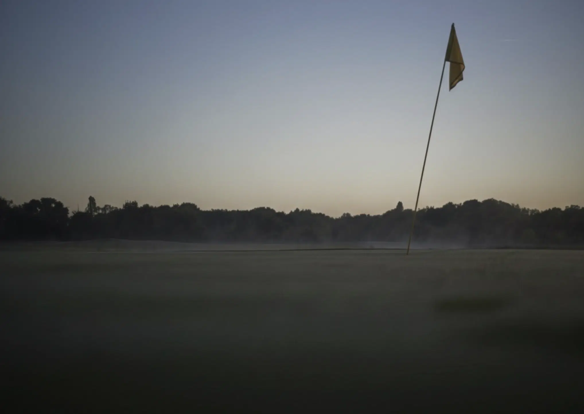 Green de golf dans une brume légère, atmosphère calme et premium Wines and Tees