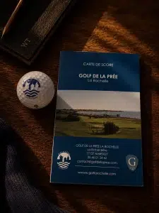 Brochure Maison Wines & Tees photographiée sur le parcours du Golf de La Rochelle