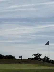 Banc face au green du Saint-Malo Golf Resort avec drapeau de golf